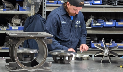 An ACS Valves technician working on a disassembled rotary airlock valve