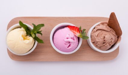 Three scoops of ice cream on a wooden board