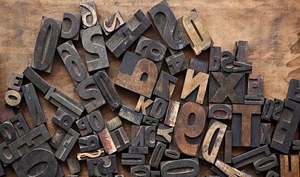 Wood and metal letters and numbers on a burnt backdrop