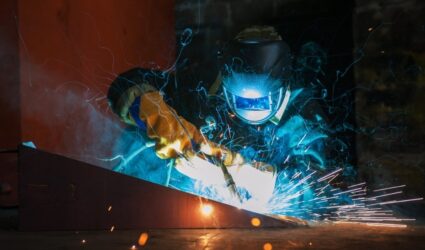 worker using a welding torch on metal