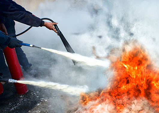 fire extinguishers being used to put our a fire