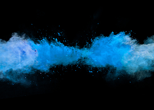 blue dust dispersing in a black background