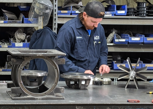 An ACS Valves technician working on a disassembled rotary airlock valve
