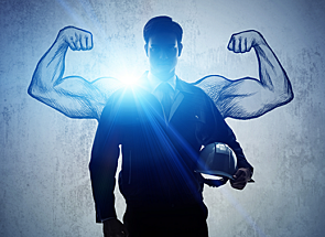 Worker with a hard-hat and uniform with cartoon muscle arms drawn in the background