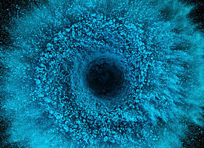 Blue dust spiraling out from the center of a black background