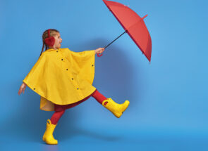Child in Rain boots and jacket with umbrella
