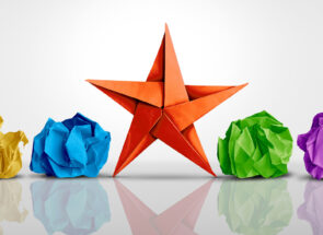 A colorful origami star with two balls of crumpled paper on either side