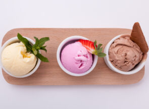 Three scoops of ice cream on a wooden board