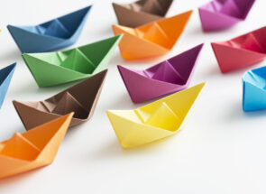 Multicolored paper boats representing new staff